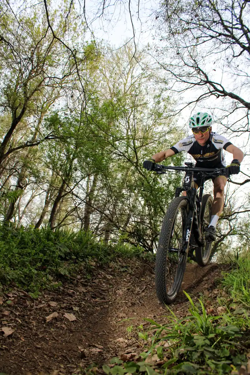 Ciclista bajando por un sendero de bosque